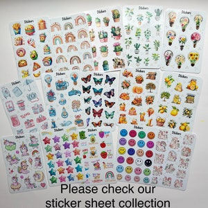 May include: A collection of sticker sheets featuring various designs, including rainbows, cacti, butterflies, food items, travel-themed illustrations, and smiley faces. The text "Stickers" appears on each sheet. The bottom of the image reads "Please check our sticker sheet collection."