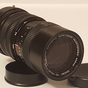 May include: A black Vivitar 70-150mm close focusing auto zoom lens with a 52mm filter thread. The lens has a serial number of 22720005.