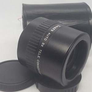 May include: A black Sears 3x Auto Tele Converter lens with a black lens cap and a black case.
