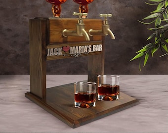 May include: Wooden liquor dispenser with two spouts and two shot glasses. The dispenser has a sign that reads "Jack Maria's Bar" with a heart symbol.