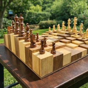 Puede incluir: Un juego de ajedrez de madera &uacute;nico con un dise&ntilde;o de tablero escalonado. Las piezas de ajedrez son de dos colores, marr&oacute;n oscuro y marr&oacute;n claro. El tablero est&aacute; hecho de bloques de madera claros y oscuros alternados, creando un efecto 3D.