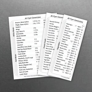 May include: Three white cards with black text listing air fryer conversion instructions for meats, frozen foods, and vegetables. Measurements are in pounds and ounces, and cooking temperatures are in Fahrenheit.