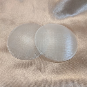 May include: Two white, round, plastic, 3D printed discs.