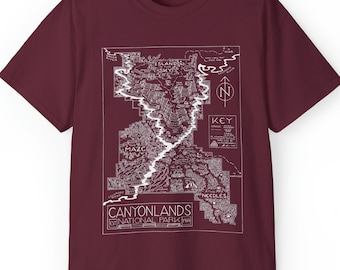 May include: A maroon t-shirt with a white graphic of a map of Canyonlands National Park. The map shows the Island in the Sky, the Maze, and the Needles districts.