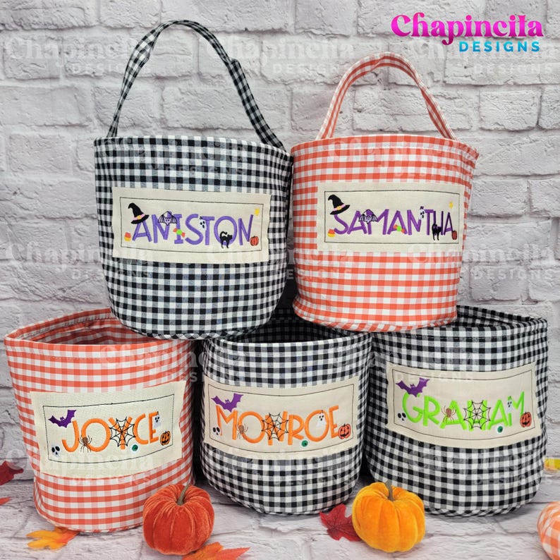 May include: Five fabric buckets with gingham patterns in black and white or orange and white. Each bucket features a rectangular patch with embroidered names including AMISTON, SAMANTHA, JOYCE, MONROE, and GRAHAM, accented with Halloween motifs.
