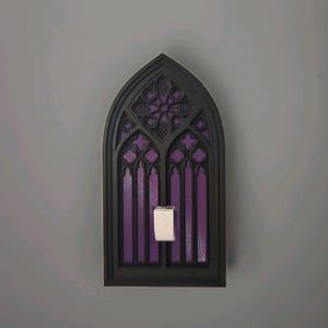 May include: A decorative light switch cover in the shape of a gothic cathedral window. The frame is black, with purple accents and a white switch. The design features intricate details and a stained-glass effect.