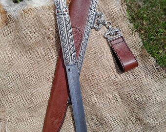 Viking scramasax. Handgesmeed lemmet van damaststaal. Bronzen handvat met Odin- en drakenkoppen. Leren schede. Middeleeuws verzamelmes