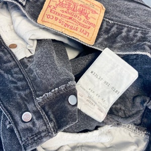 May include: A pair of black denim jeans with a Levi Strauss & Co. label and a size tag that reads "W33L32 901 0185".
