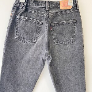 May include: A pair of dark gray denim jeans with a Levi's brand patch on the back pocket.