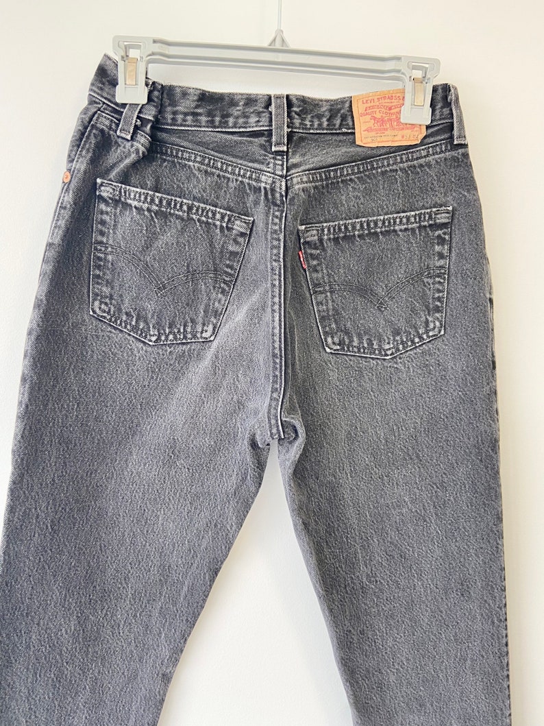 May include: A pair of dark gray denim jeans with a Levi's brand patch on the back pocket.