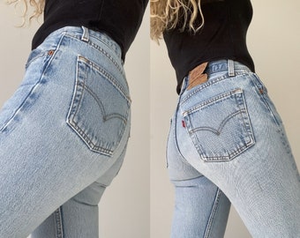 May include: A pair of light blue denim jeans with a classic five-pocket style. The jeans have a high waist and a straight leg.