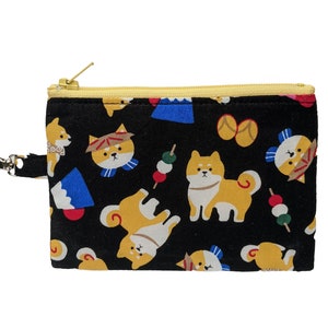 May include: A black zippered pouch with a yellow zipper pull. The pouch is decorated with a repeating pattern of Shiba Inu dogs, Japanese food, and traditional Japanese clothing.