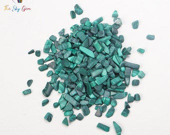 May include: A pile of small, green malachite chips. The chips are irregularly shaped and have a smooth, polished surface.