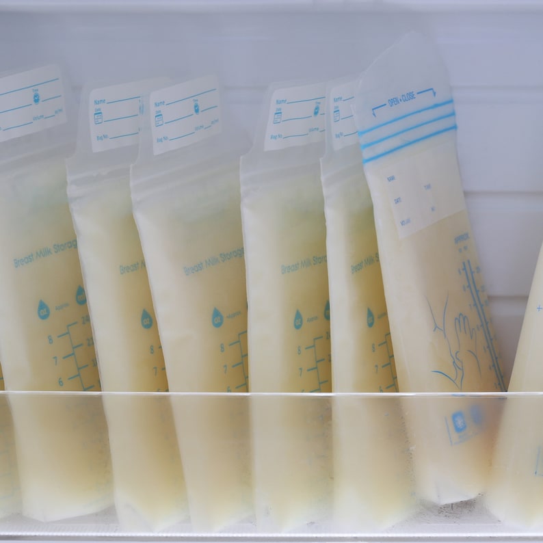 Puede incluir: Varias bolsas de pl&aacute;stico transparentes llenas de leche materna se almacenan en un refrigerador. Las bolsas tienen etiquetas que dicen "Breast Milk Storage" y tienen marcas de medici&oacute;n en onzas.