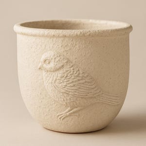May include: A white ceramic planter with a textured surface and an embossed bird design.