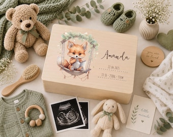 May include: A rectangular wooden keepsake box featuring a printed illustration of a fox sitting on a swing, the name Amanda, the date 22.04.2025, and birth details 13:16 - 2380g - 53cm. The box is surrounded by a teddy bear, baby shoes, and photos.