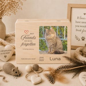 Peut inclure: Un coffret commémoratif en bois pour animaux de compagnie avec une photo d'un chat nommé Luna. Le coffret porte l'inscription "Best Friends Are Never Forgotten" et "Forever in my heart". Autres éléments : bougie, pierres en forme de cœur et figurine de chat.