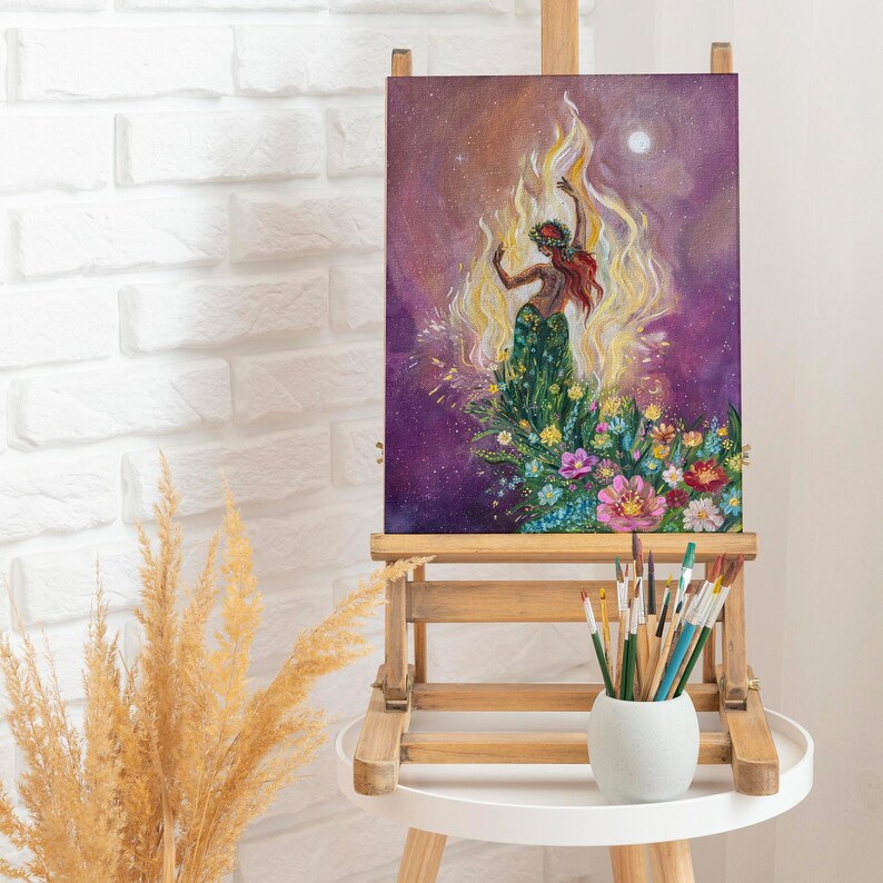 May include: A painting on canvas depicting a woman in a green dress standing in a field of flowers. The woman is surrounded by flames and the background is a purple sky with stars.
