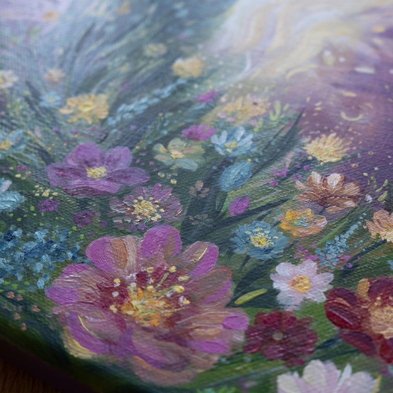 May include: A close-up of a painting depicting a field of wildflowers in shades of pink, purple, blue, and yellow. The flowers are painted with a textured brushstroke, giving the painting a realistic feel.
