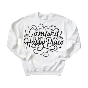 Może przedstawiać: Biała bluza z czarnym napisem "Camping is my happy place" z wzorem chmury i g&oacute;r.