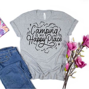 Może przedstawiać: Szary T-shirt z napisem "Camping is my Happy Place" w czarnym kolorze. Tekst jest otoczony wzorem chmury z gwiazdami i g&oacute;rami.