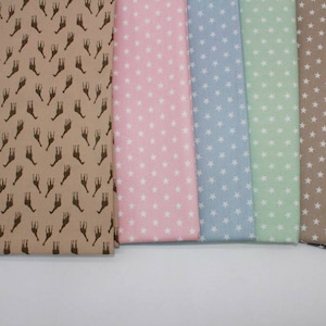 May include: A collection of fabric swatches featuring various patterns. The swatches include a brown fabric with a giraffe print, a pink fabric with white stars, a light blue fabric with white stars, a light green fabric with white stars, a beige fabric with white stars, and a grey fabric with white stars.