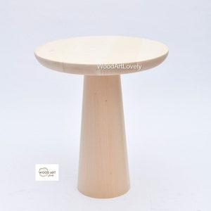 Op de afbeelding: Een licht houten bijzettafel met een rond blad en een hoge, cilindrische basis. De tafel is gemaakt van natuurlijk hout en heeft een eenvoudig, modern ontwerp. De tekst "WoodArtLovely" is zichtbaar op het tafelblad.