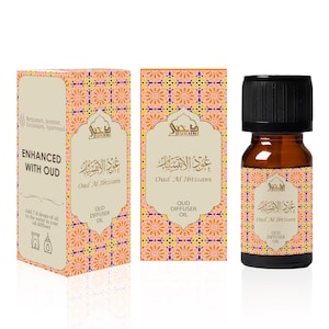 May include: A brown glass bottle with a black cap containing Oud Al Ibtisam diffuser oil. The bottle is labeled with Arabic text and the words "Oud Al Ibtisam" and "Oud Diffuser Oil". The bottle is sitting on a white surface with a reflection.