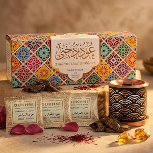 May include: A Dukhni Oud Bakhoor variety box with a rainbow burner. The box has a colorful geometric pattern. Three small packets of Oud Saher, Oud Habayeb, and Oud Al Awatef are displayed. Rose petals, saffron, and amber-colored stones are also present.
