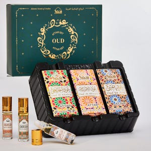 May include: A set of three small glass bottles of Oud attar perfume in a black box. The bottles are labelled with Arabic script and the words "Oud Al Khaleeji", "Oud Al Jbtisa", and "Oud Ya". The box is labelled with the words "Attar Set OUD Attar Set".