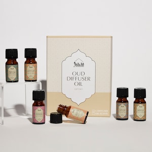 May include: A gift set of Oud Diffuser Oil, presented in a box with the words "OUD DIFFUSER OIL GIFT SET". The set includes six small brown glass bottles with black caps and patterned labels. The bottles are displayed on a white surface.