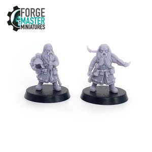 Può includere: Due miniature di plastica grigia di nani, una tiene un elmo e l'altra un'arma. Le miniature sono in piedi su basi nere. Il testo "FORGE MASTER MINIATURES" è visibile sullo sfondo.