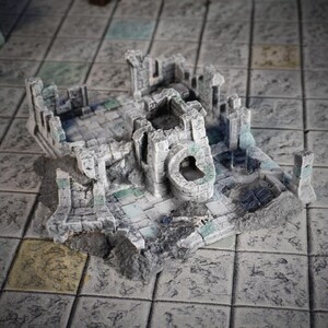 Peut inclure: Une ruine miniature en pierre grise avec une petite porte cintrée et un mur en ruine. La miniature est conçue pour les jeux de table.