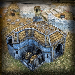 May include: A miniature model of a stone building with a gold roof and intricate details. The building has a tower and a large, open doorway. The model is set on a textured surface.