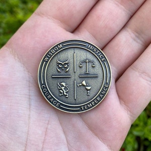 May include: A round, gold-colored metal token with four sections. Each section has a different symbol and word: Wisdom (owl), Justice (scales), Courage (lion), and Temperance (chalice).