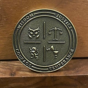 May include: A round, bronze-colored coin with four sections. Each section features a symbol and a word: Wisdom (an owl), Justice (scales), Courage (a lion), and Temperance (a cup).