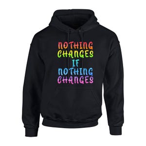 May include: A black hooded sweatshirt featuring the text "NOTHING CHANGES IF NOTHING CHANGES" printed on the front. The letters are filled with a multi-colored, horizontal striped pattern in shades of red, orange, yellow, green, blue, and pink.