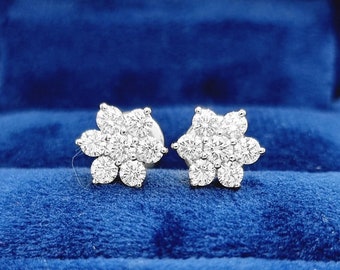 May include: A pair of diamond flower-shaped stud earrings in a blue velvet jewelry box.