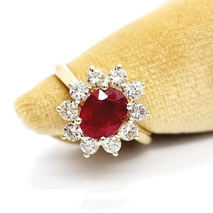 以下が含まれることがあります： ダイヤモンドで囲まれた大きな赤いルビーが付いた金の指輪
