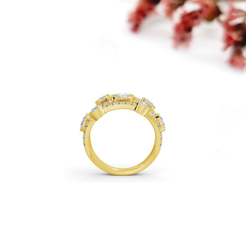 May include: A gold band ring with multiple small, clear, square-shaped stones set in a pave setting.