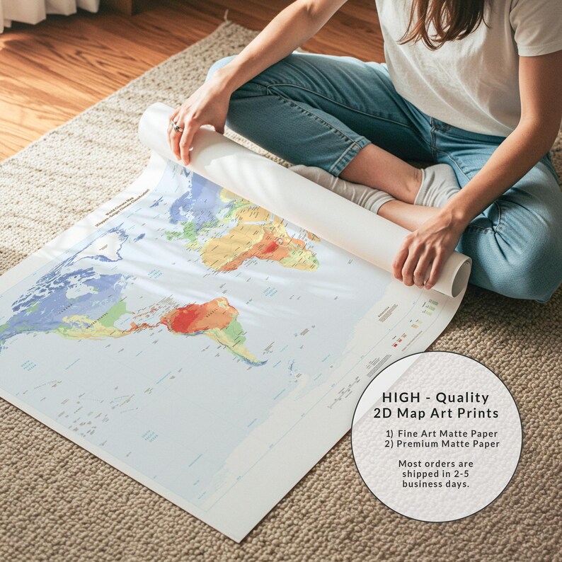 May include: A large, rolled-up world map print on matte paper featuring colorful continents against a light blue ocean background. The map displays various geographical regions in shades of green, yellow, and red, with clear text labels for countries and oceans visible across the surface.
