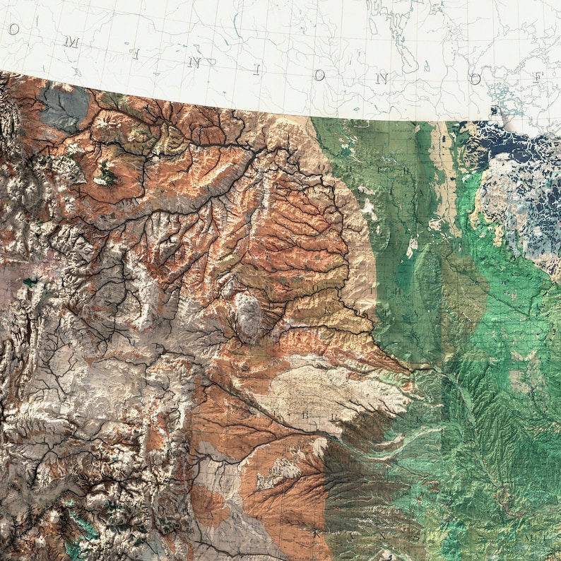 May include: A detailed topographical map with a blend of earthy tones, including shades of brown, beige, and green. The map highlights mountainous regions and river systems, with a portion of a white and gray map in the upper right corner.