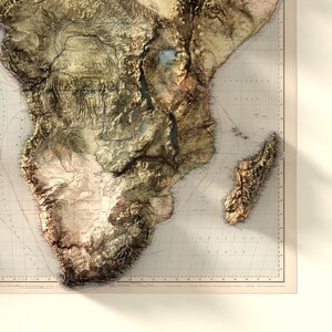 May include: A vintage map of Africa with a 3D embossed effect, showing the continent's topography and geographical features. The map is printed on a light beige background with brown and green colors to represent the terrain.