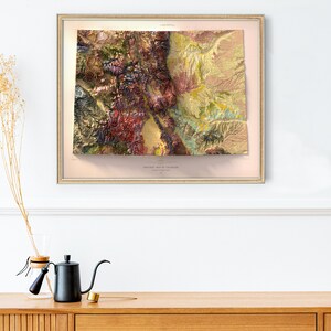 May include: A framed geological map of Colorado, featuring a detailed relief with various colors representing different geological formations. The map is in a gold-colored frame and hangs on a white wall. The text "GEOLOGICAL MAP OF COLORADO" is visible.