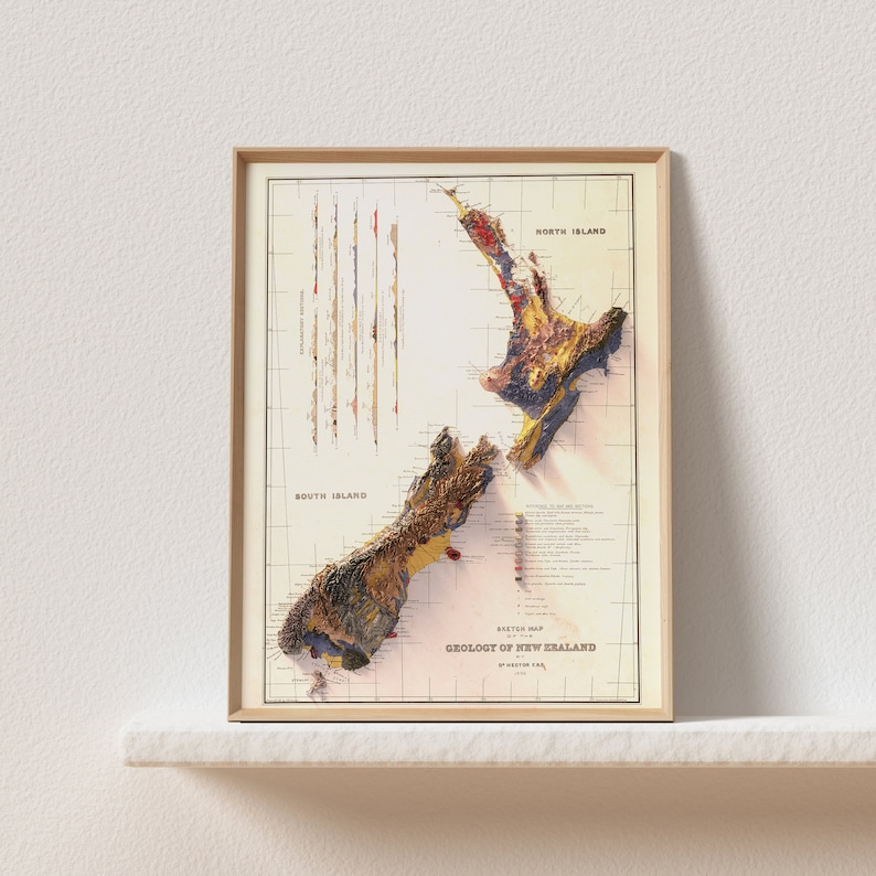May include: A vintage map of the geology of New Zealand, framed in a light wood frame. The map shows the different geological formations of the North and South Islands, with a key to the different rock types. The map is titled "Sketch Map of the Geology of New Zealand" and is dated 1915.