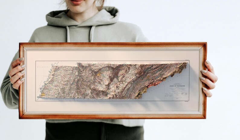 May include: A framed 3D relief map of the state of Tennessee. The map is in a brown wooden frame and shows the state's topography in detail.