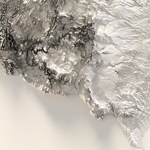 Pu&ograve; includere: Una mappa topografica in bianco e nero di una regione montuosa. La mappa mostra l'altitudine del terreno con diverse tonalit&agrave; di grigio. Le montagne sono molto dettagliate e la mappa &egrave; molto realistica.