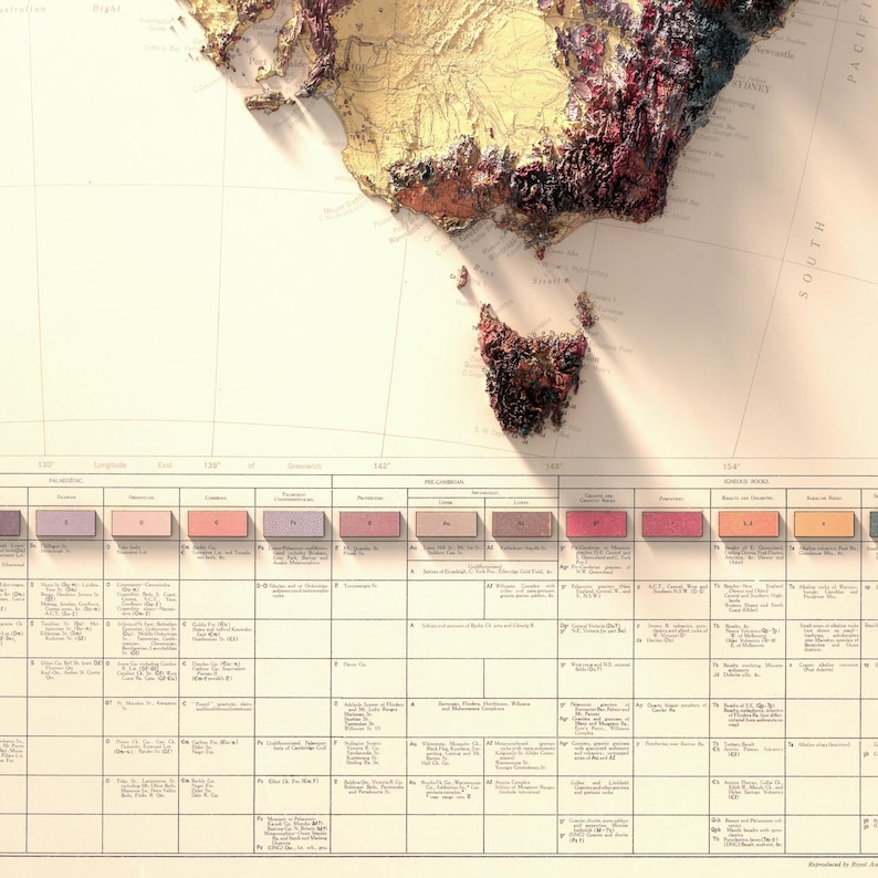 May include: A vintage map of Australia with a 3D effect, showing the terrain in shades of brown, red, and pink. The map includes a color key with different shades of brown, red, and pink, and a table with descriptions of the different geological formations.