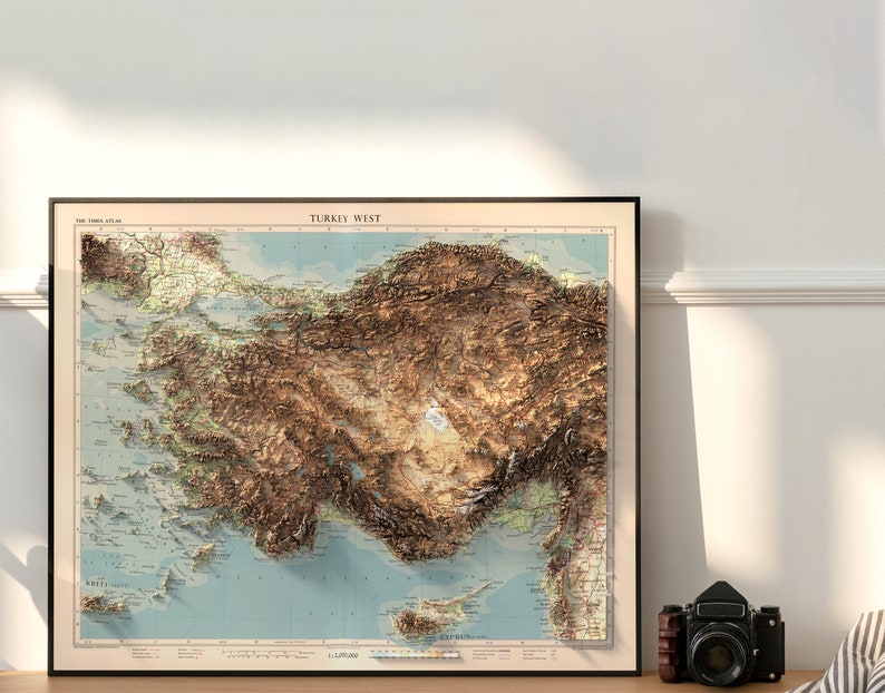 May include: A vintage-style map of Turkey West, showing the topography of the region in brown and green hues. The map is framed in a black frame and has a scale of 1:1,000,000.