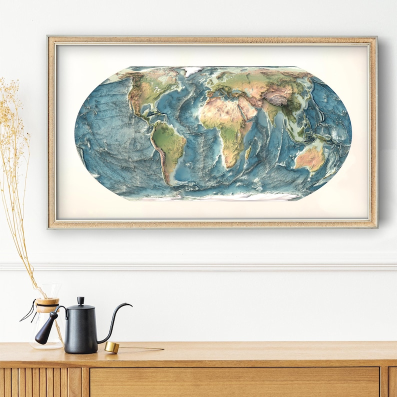 May include: A rectangular framed wall art piece featuring an oval-shaped physical relief map of the world. The map displays continents in shades of green and tan, contrasted against deep blue ocean depths, all encased in a light wood frame.